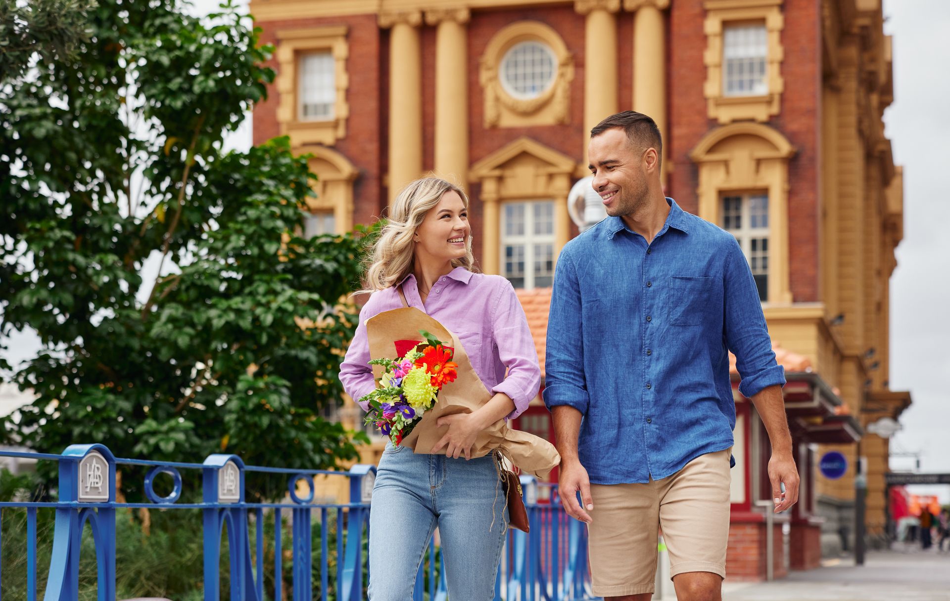 Couple smiling while holding a bouquet of flowers