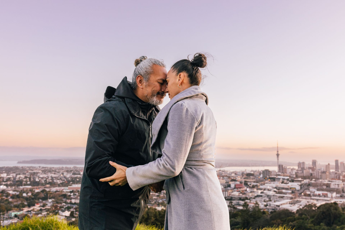 Two people share a hongi atop Maungawhau / Mount Eden in Auckland
